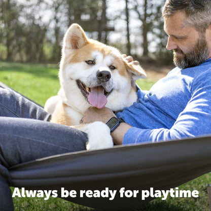 dog and owner hanging out in their yard in a hammock